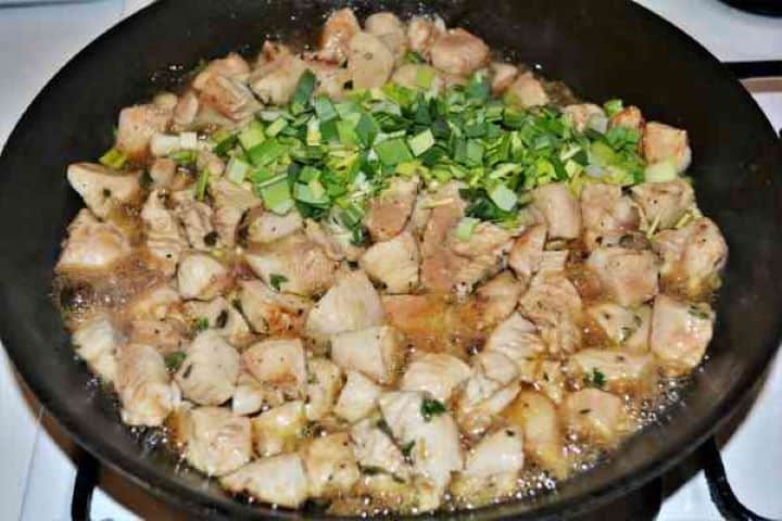 Chicken Breast With Pineapple-Add Chopped Leek to Frying Chicken Cubes in the Pan Adding chopped fresh leeks to the skillet with sautéed chicken breast cubes.