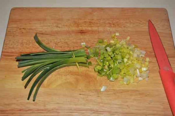 Chicken Breast With Pineapple-Chopping the Leek Finely chopping fresh leeks on a cutting board for the cold chicken and pineapple salad.