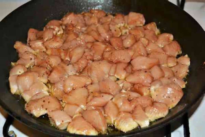 Chicken Breast With Pineapple-Frying Chicken Cubes in the Pan Sautéing seasoned chicken breast cubes in a deep frying pan with hot olive oil.