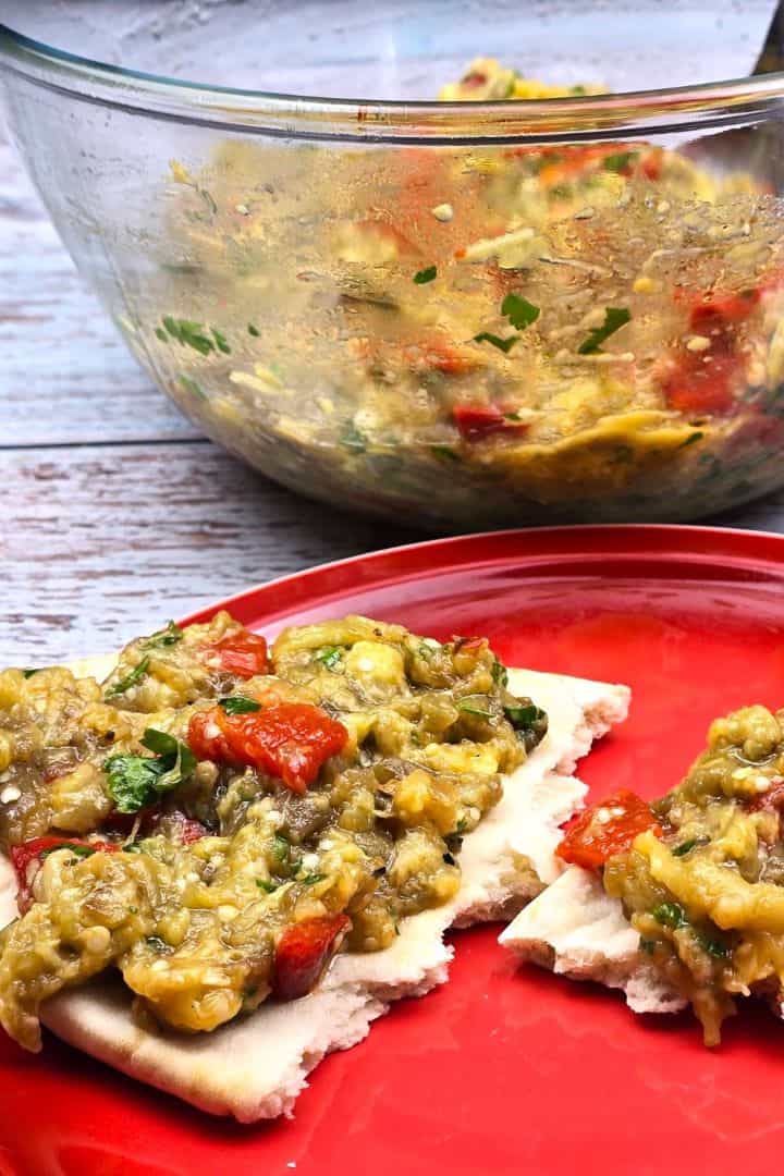 A bowl of homemade smoky Greek eggplant dip (Melitzanosalata) served alongside warm pita bread.