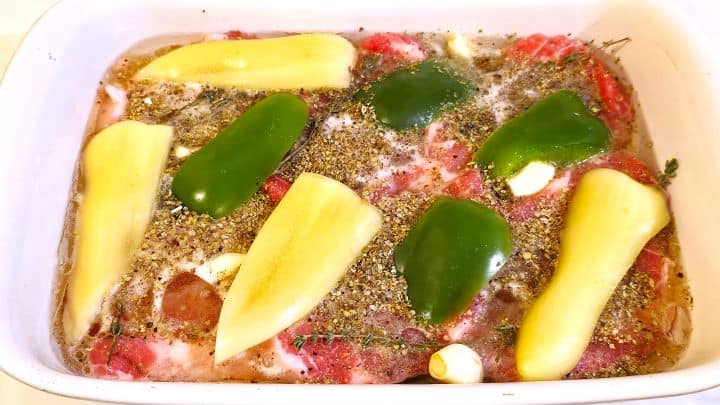 Easy Oven Baked Pork Steak Recipe-Pour Olive Oil and Beer on the Pork Neck Slices Pepper Slices and Seasoned With Aromatic Plant Pork Shoulder Steaks Soaked in Beer in the Ceramic Tray