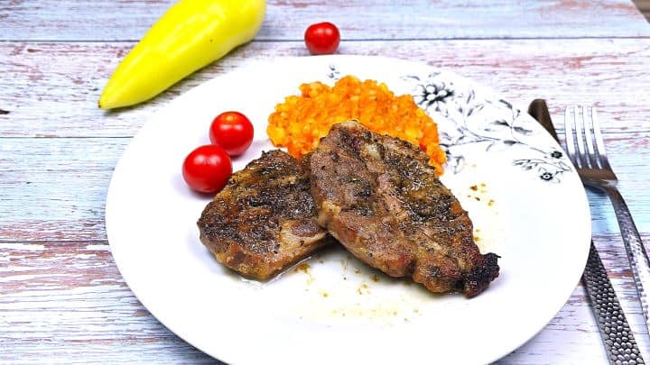 Oven-Baked Pork Steak Served on White Plate With Potatoes