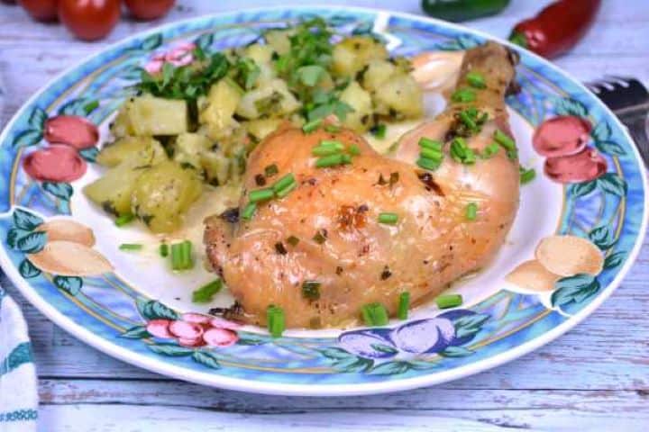 Served Juicy garlic butter roast chicken leg presented with side salad and chopped chives.