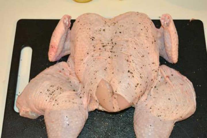Seasoned Spatchcocked chicken seasoned with coarse sea salt and black pepper.