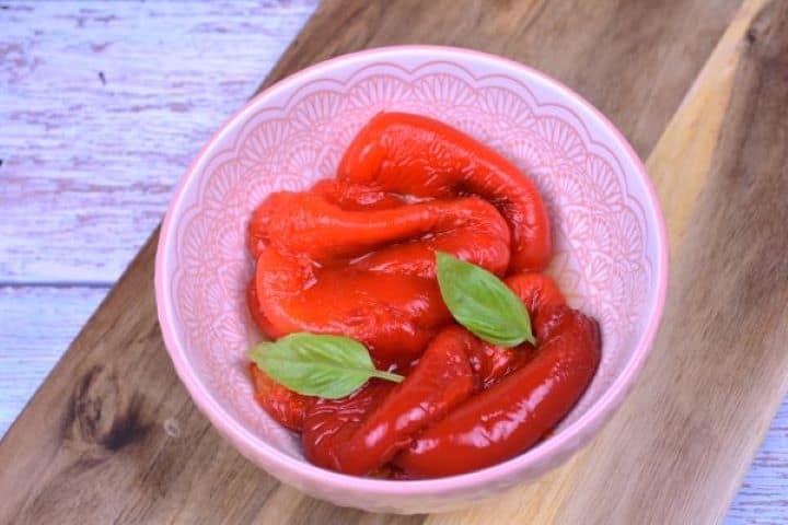Marinated Roasted Red Peppers-Served in the Bowl Homemade marinated roasted red peppers ready to serve as a delicious side dish or sandwich topping.