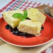 Sweet Noodle Kugel With Raisins Served on Plate With Blueberry Jam on Bottom