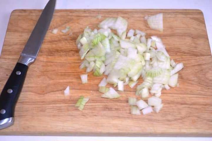 Chopped Onion Finely chopped yellow onion on a cutting board.