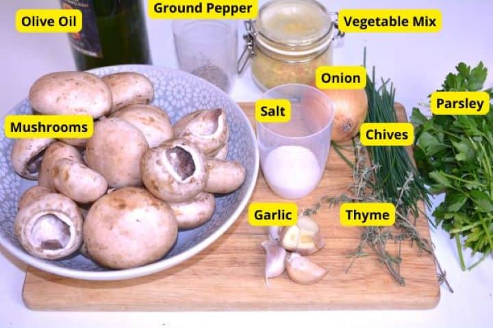 Ingredients Fresh ingredients for vegan garlic mushrooms including white button mushrooms, garlic, olive oil, fresh thyme, parsley, and chives.
