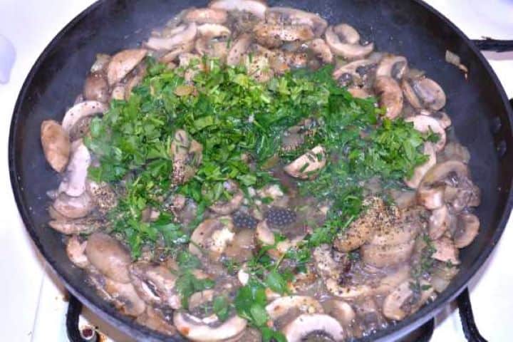 Sautee Seasoning sautéed mushrooms with pressed garlic cloves, fresh thyme leaves, black pepper, and sea salt.