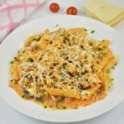 Creamy pork mince pasta with mushrooms served on a white plate topped with grated Parmesan and fresh parsley.