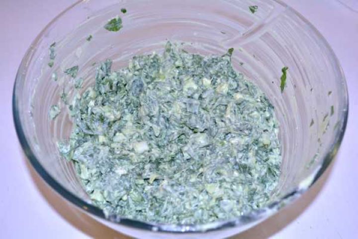 Creamy spinach and feta cheese filling stirred smoothly in a mixing bowl.
