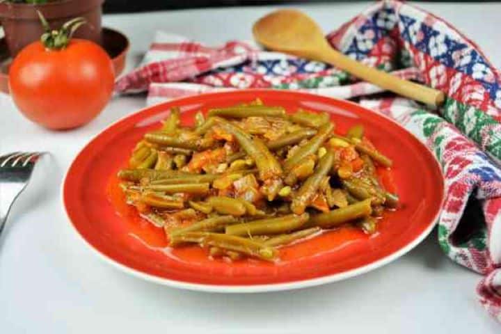 Served Serving portion of warm green beans in tomato sauce as a healthy side dish.
