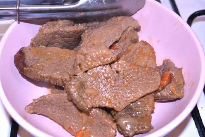 Cooked Fork-tender cooked beef slices removed from the stew liquid and set aside in a bowl.