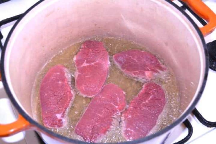 Fry the Meat Searing beef cutlets in hot pork lard inside a cast-iron Dutch oven.