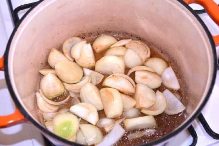 Onions Diced onions sautéing in pork fat in a Dutch oven until softened.