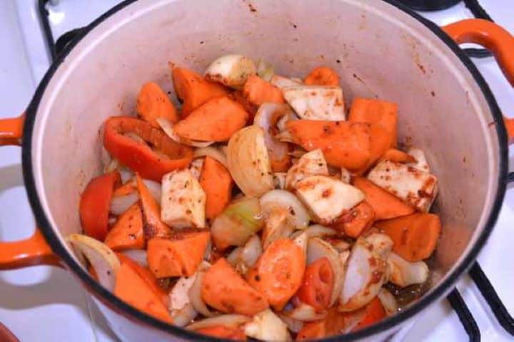 Vegetables Sautéing carrots, parsley root, thyme sprigs, and tomato paste with onions.
