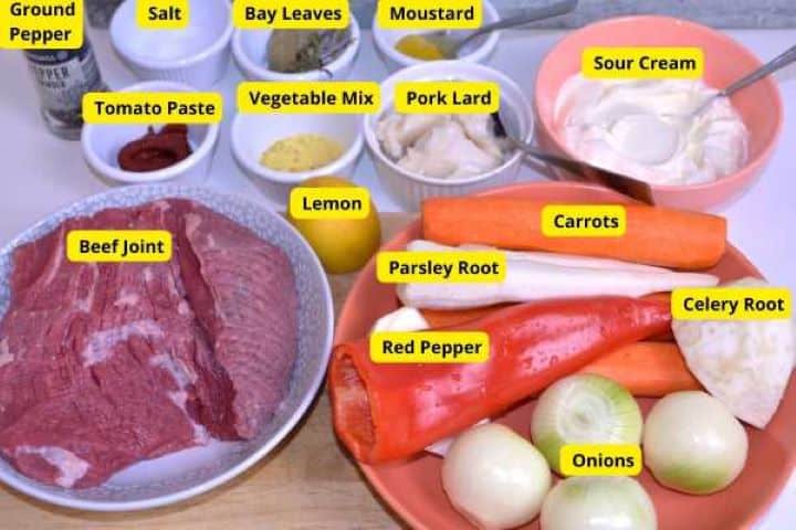 Fresh ingredients for Hungarian hunter's stew including beef joint, carrots, celery root, and onions.