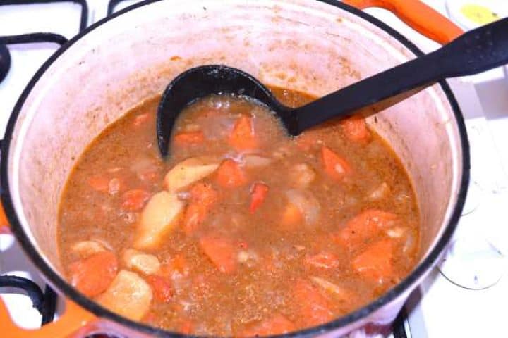 Stewed Braised root vegetables and cooking broth in the pot before blending into sauce.