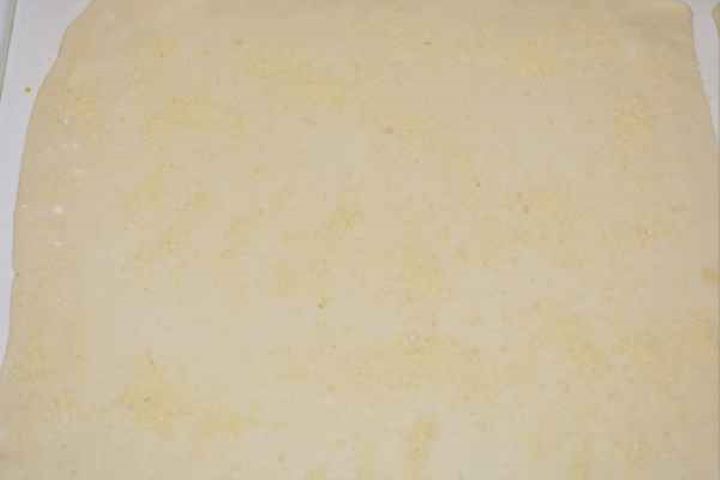 Apple Shortcrust Pastry Recipe-Half of Shortcrust Pastry on the Table A rolling pin flattening a rectangular sheet of ready-rolled shortcrust pastry on a floured surface.