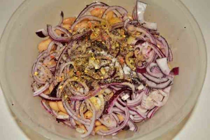 Butter Beans Salad Recipe-Seasoned Ingredients in the Bowl Seasoning butter beans and onions with salt, pepper, and sunflower oil.