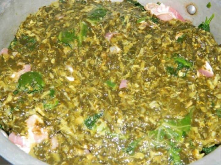 The final top layer of salted sorrel completely covering the stuffed collard greens and bacon.