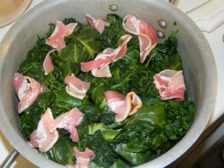 Slices of savory smoked bacon tucked over the spinach and greens inside the pot.