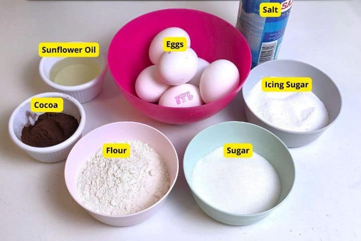 Ingredients for chocolate Swiss roll sponge including eggs, flour, sugar, and cocoa powder.