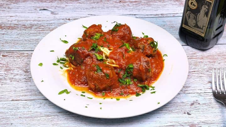 Tender Romanian meatballs in a rich garlic tomato passata sauce served over a bed of spaghetti pasta.