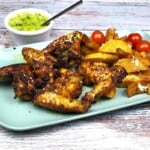 Oven Baked Whole Chicken Wings Served On Plate With Fries and Garlic Dip
