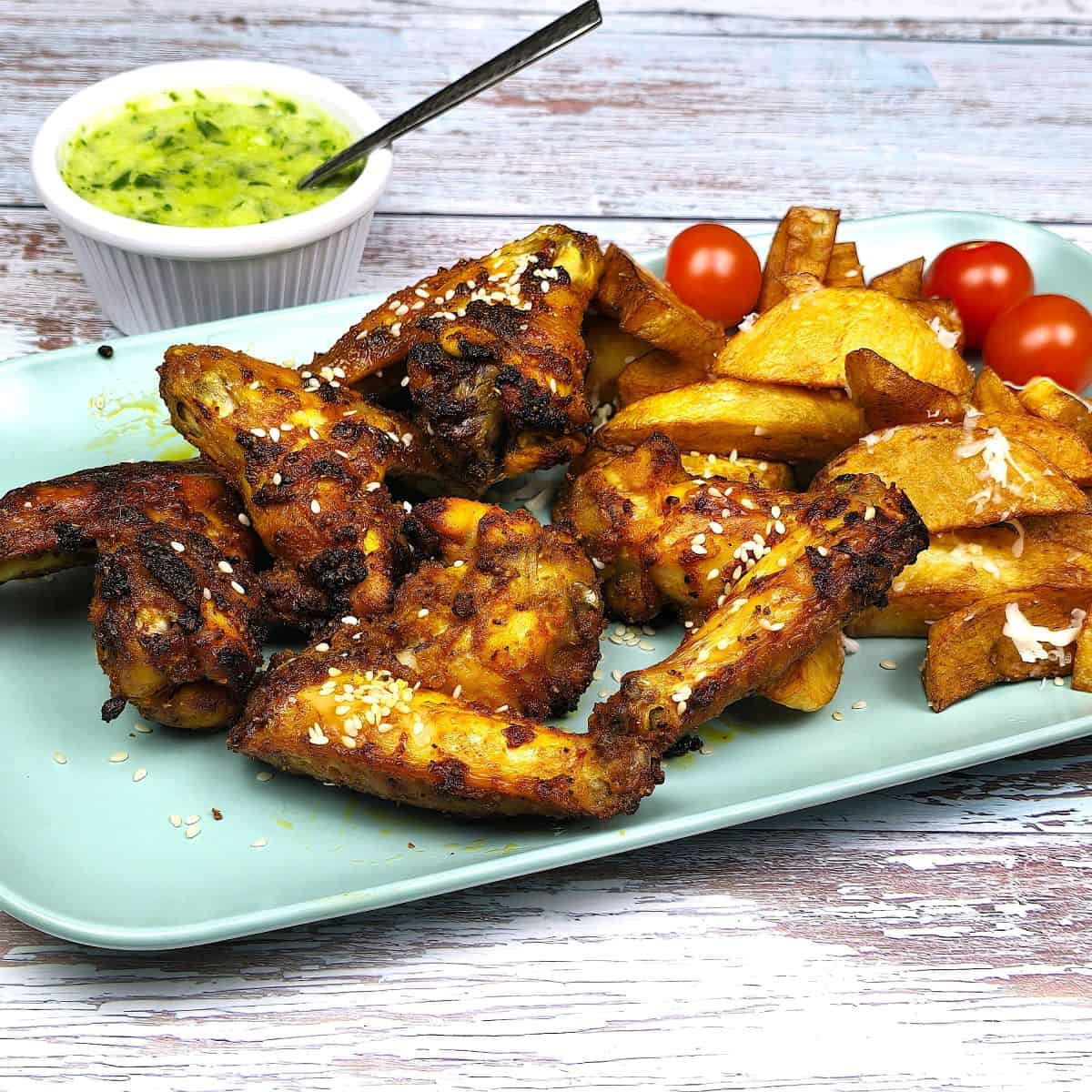 Oven Baked Whole Chicken Wings Served On Plate With Fries and Garlic Cream