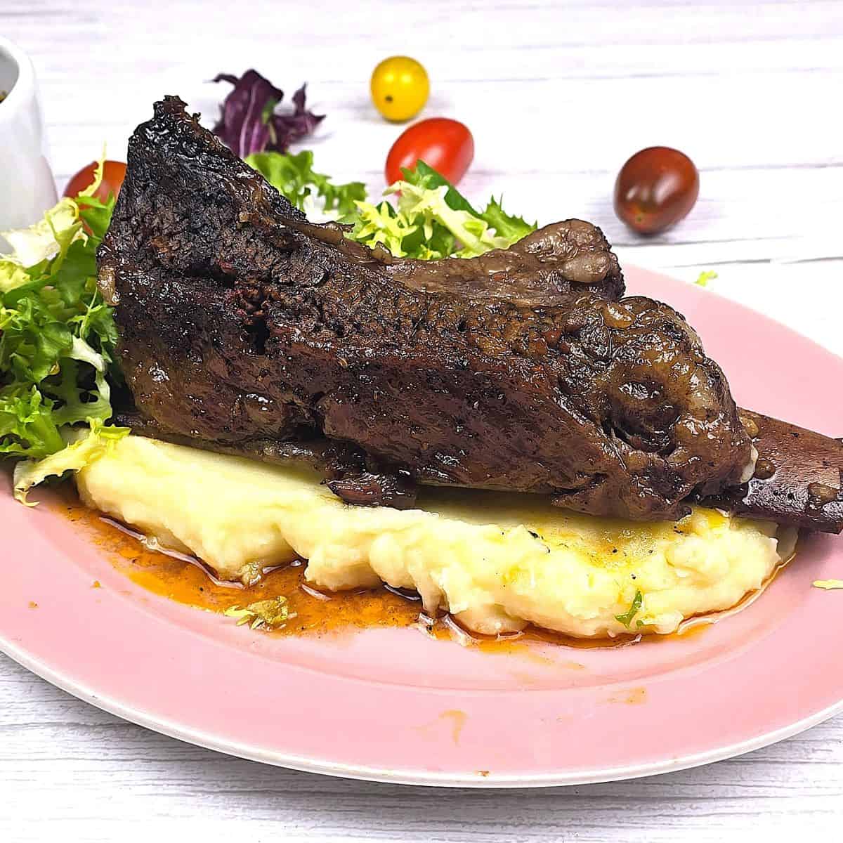 Oven Baked Short Ribs Served on Plate With Mashed Potato and Salad