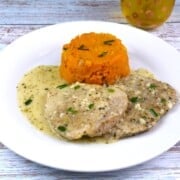 Creamy Garlic Pork Chops Served on White Plate With Potatoes
