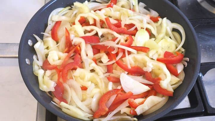 Sauteeing Sliced Onions and Peppers in the Pan