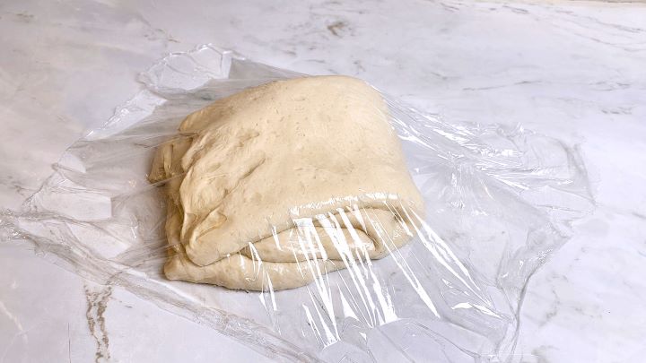 Folded Bread Dough Covered With Plastic Foil on the Table