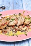 Pork Tenderloin in Creamy Mushroom Sauce Served on Pink Oval Plate With Parsley