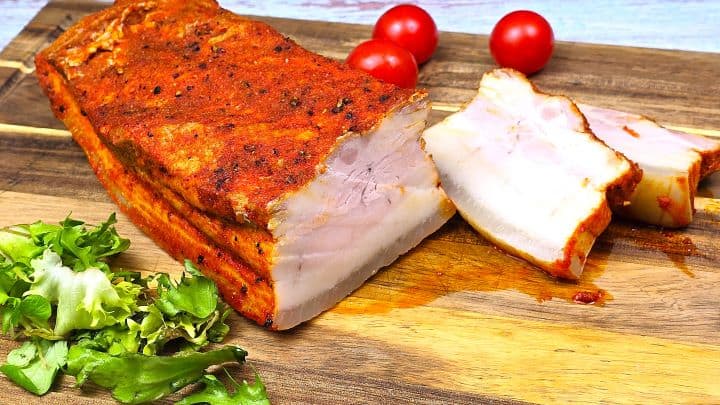 Boiled Pork Belly Appetizer Sliced and Served on the Chopping Board With Lettuce and Cherry Tomatoes
