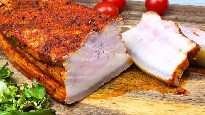 Boiled Pork Belly Appetizer Sliced and Served on the Chopping Board With Cherry Tomatoes