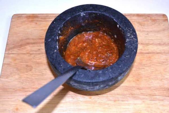 Paste Garlic, paprika, and marjoram seasoning paste mixed with rendered duck fat in a mortar.