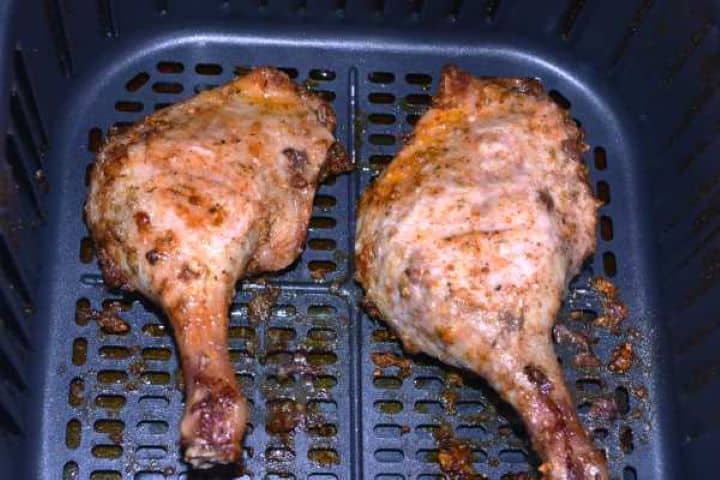 Half Cooked Checking internal cooking temperature of crispy air fryer duck leg with a meat thermometer.