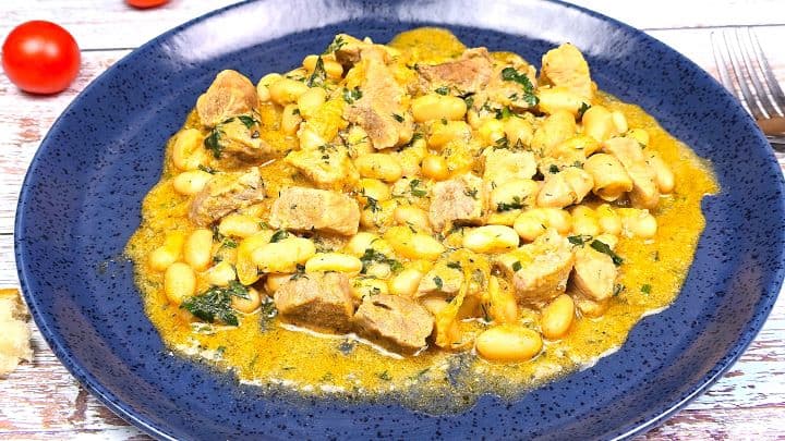 Pork and White Bean Stew Served on Blue Plate With Bread