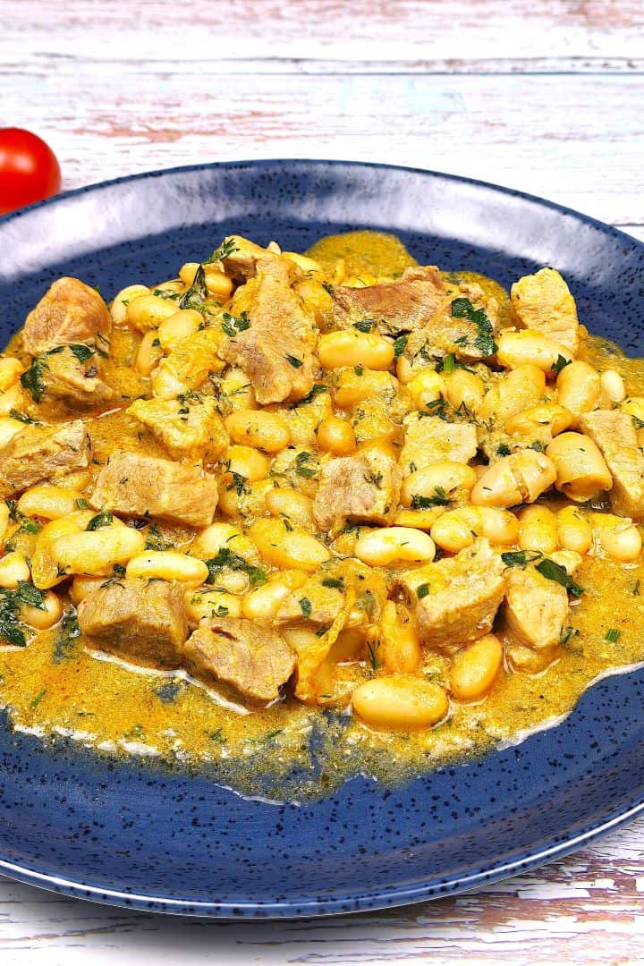 Pork and White Bean Stew Served on Plate With Bread