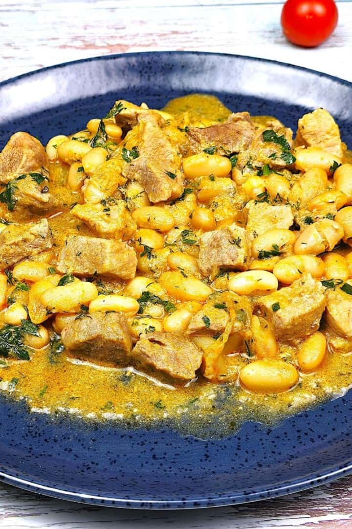 Blue Plate of Creamy Pork and White Bean Stew with fresh bread - timeaskitchen.com