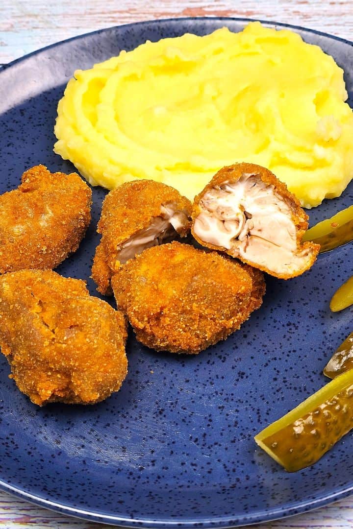 Crispy Breaded Pork Brain Served on Blue Plate With Mash and Pickles