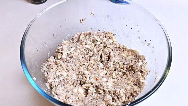 Cheesy chicken filling mixture with feta, egg, and herbs combined in a bowl.
