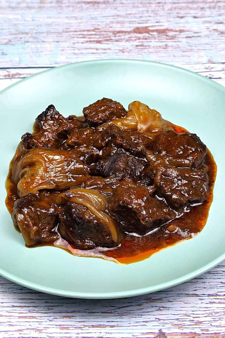 Authentic Greek beef stifado with tender beef chunks and whole caramelized shallots in a rich red wine sauce.