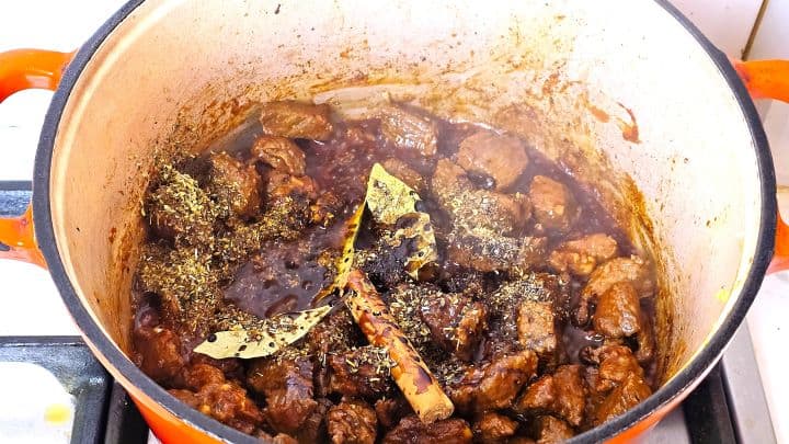 Seared beef seasoned with a whole cinnamon stick, bay leaves, crushed garlic, tomato purée, oregano, and nutmeg.